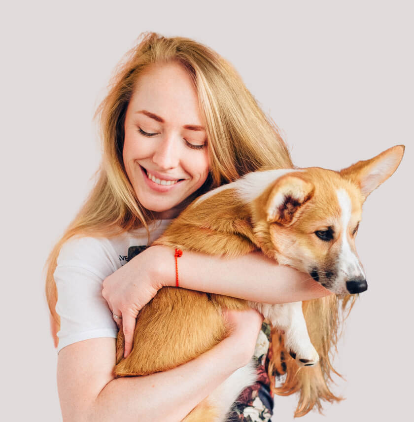 a woman holding a Corgie
